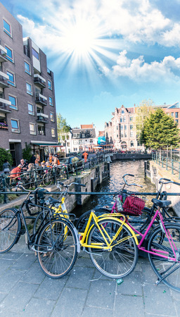 Amsterdam. Colourful yellow and pink Bicycles over the Canal.のeditorial素材