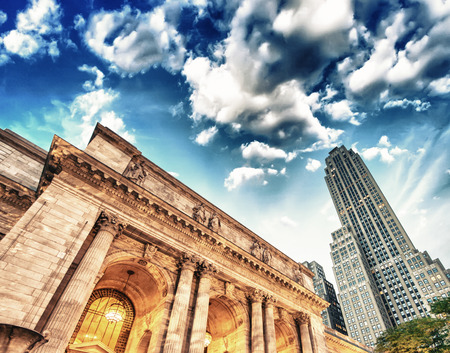 The New York Public Library. Side view with surrounding buildings and dramatic sky.のeditorial素材