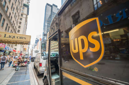 NEW YORK CITY  - MAY 13, 2013: The ups-logo on a UPS van in the streets of New York, people walking by in the reflection of the vanのeditorial素材