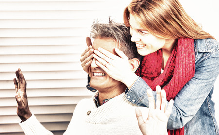 Smiling wife making a surprise to her husband for Christmas.のeditorial素材