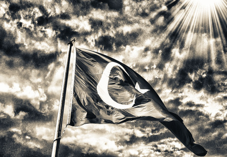 Flag of Turkey waving in the wind with highly detailed fabric texture against sunset sky.
