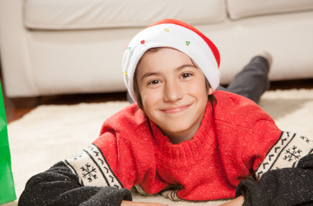 Happy boy at home smiling for Christmas on the rug.のeditorial素材