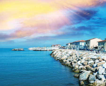 Rocks over the oceans. Beautiful seascape with village homes at sunset.の写真素材