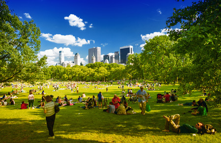 CENTRAL PARK, NEW YORK - JUNE 14, 2013: People enjoy outdoor life under park trees. Central Park is a public park at the center of Manhattan, which opened in 1857, on 778 acres of city-owned land.のeditorial素材