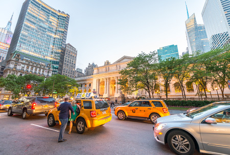 NEW YORK CITY - JUNE 8, 2013: Tourists and traffic on Fifth Avenue. The city is visited by more than...