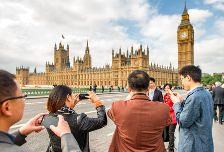LONDON - SEPTEMBER 29, 2013: Tourists walk along Westminster Bridge. The city is visited by more than 30 million people annually.のeditorial素材
