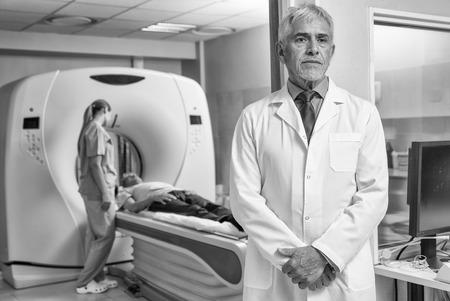 Confident male doctor in hospital with patient undergoing mri.の写真素材