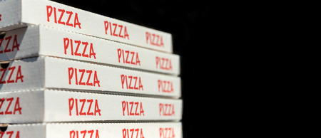 Large stack of pizza boxes. Isolated over black.の写真素材