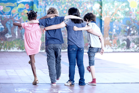 Happy classroom playing at school. Multi ethnic children, back view.の写真素材