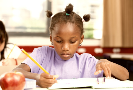Afro american girl at school desk.の写真素材