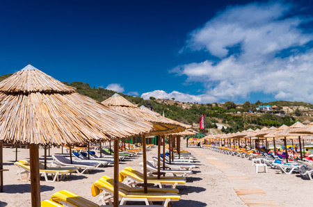 Rows of straw umbrellas on a beautiful beach.の写真素材