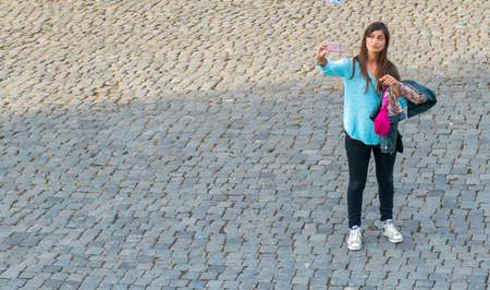 ROME - MAY 20, 2014: Tourist makes a selfie near Colosseum. The city is visited by more than 10...