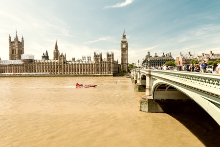 LONDON - MAY 10, 2015. Tourists relax along Westminster Bridge. London welcomes 30 million visitors...