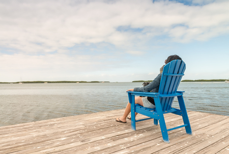 Woman relaxing seated near the ocean.の写真素材