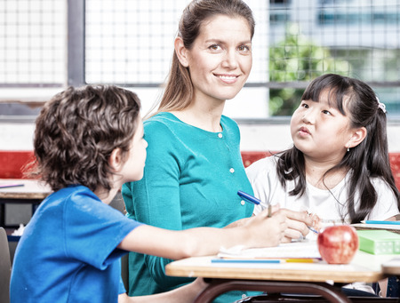 Beautiful teacher with mixed race classroom.の写真素材