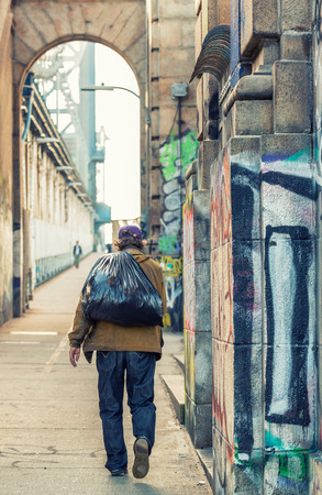 Homeless walking along Manhattan Bridge, New York City.の写真素材