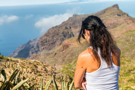 Deep thinking woman outdoor with mountain scenario. Sadness and lonelyness conceptの写真素材