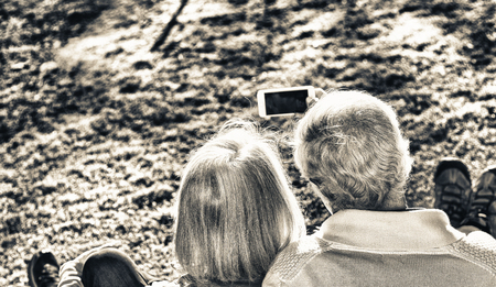 Retired couple making a selfie in a garden. Happiness and union concept.