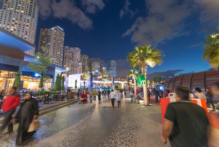 DUBAI, UAE - DECEMBER 10, 2016: Dubai Marina promenade at sunset. Dubai attracts 15 million tourists annually.のeditorial素材