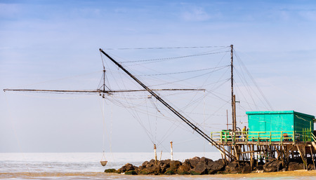 Wooden house in the middle of the sea over rocks.の写真素材