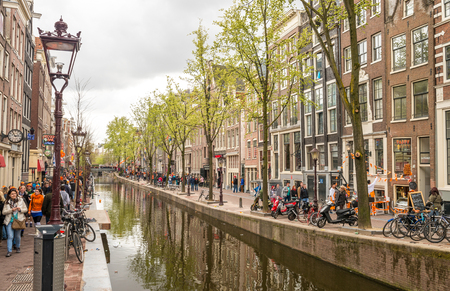 AMSTERDAM - MAY 1, 2013: Tourists along city streets for Queen's Day. Amsterdam attracts 10 million visitors every year.のeditorial素材