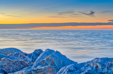 Rocks bove the ocean with sunset.の写真素材