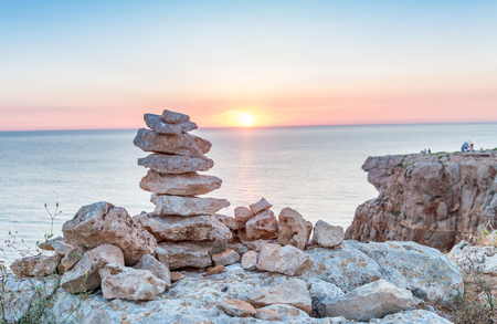 Stacked stones over the sea at sunset.