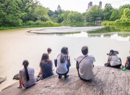 Blurred view of people looking at Central Park Lake, NYC.の写真素材