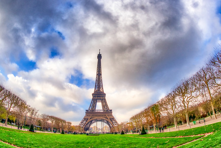 Wide angle upward view of Tour Eiffel as seen from surrounding gardens.