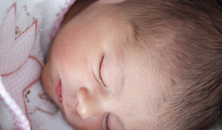Newborn Baby Girl relaxing inside her Bedの写真素材