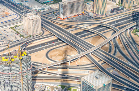 DUBAI, UAE - NOVEMBER 22, 2015: Dubai skyline and road intersection, aerial view. Dubai attracts 30 million people every year.のeditorial素材