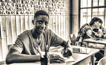 African male teenager making lesson in the classroom and happy about the test.のeditorial素材