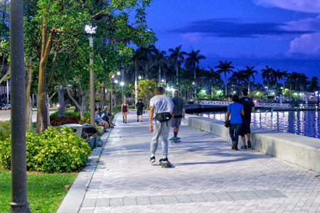 WEST PALM BEACH, FL - APRIL 9, 2018: Tourists and locals enjoy riverfront at night. The city is a famous attraction in Florida.のeditorial素材