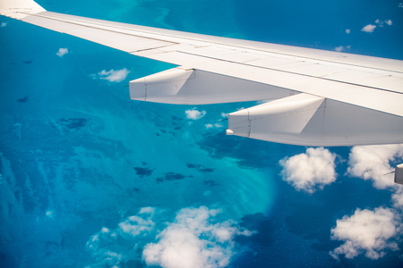 Airplane wing overflying beautiful ocean. Vacation concept.の写真素材