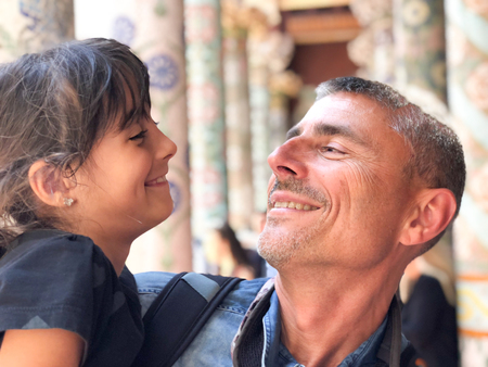 Happy father and daughter looking each other while visiting monument.の写真素材