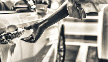 Woman hand opening car door inside a parking.の写真素材