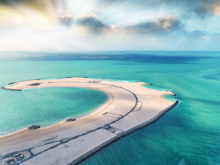 Piece of sand in the ocean. Beach, road and water, aerial view.の写真素材
