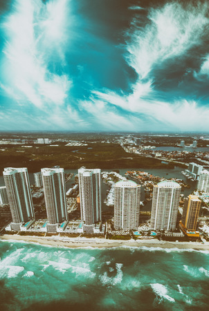 Helicopter view of North Miami Beach skyscrapers with sun and clouds.の写真素材