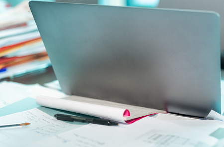 Modern notebook on a cluttered desktop.