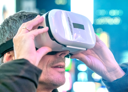 Man with Virtual Reality Visor in the city center surrounded by lights, light rays coming from above