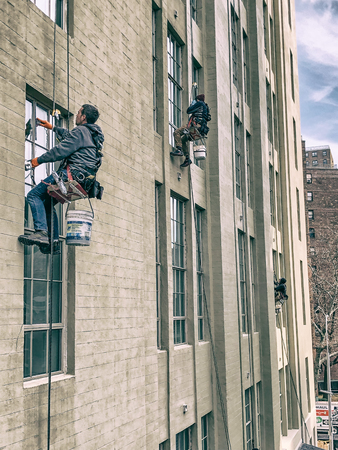 NEW YORK CITY - DECEMBER 1, 2018: Window washers at work on a sunny day. They have to clean buildings facades.のeditorial素材