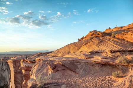 Tourists enjoying Horseshoe Bend at sunset, Arizona.