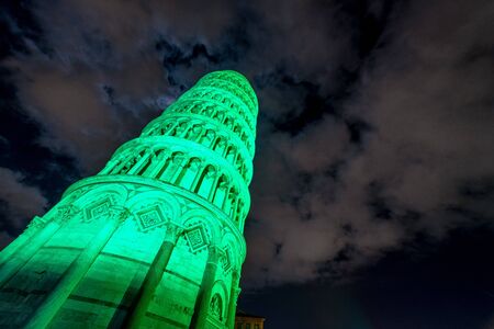 Pisa Tower in Miracles Square for St Patrick's Day illuminated by green lights, Tuscany - Italy.の写真素材
