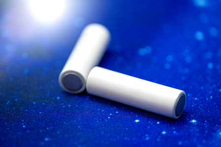 Couple of white AA batteries isolated on a blue blackground.の写真素材
