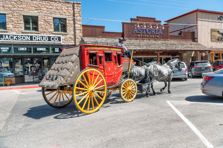JACKSON HOLE, WY - JULY 11, 2019: Colorful horse carriage with tourists in the town. Jackson is a famous tourist destination.のeditorial素材