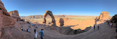 ARCHES NATIONAL PARK, USA - JULY 2, 2019: Panoramic view of Delicate Arch and tourists.のeditorial素材