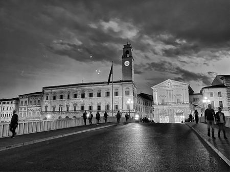 PISA, ITALY - SEPTEMBER 27, 2019: Ponte di Mezzo with tourists at sunset.