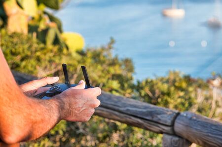 Man's hands controlling remotely his drone.