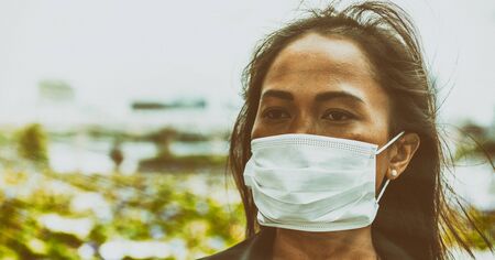Asian woman enjoying outdoor time wearing hygienic mask to prevent the virus PM2.5 and Coronavirus....