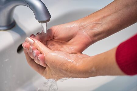 Woman washing hands at home. Coronavirus prevention against virus outbreak.の写真素材
